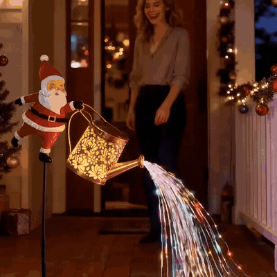 Papá Noel solar con regadera iluminando la entrada de una casa